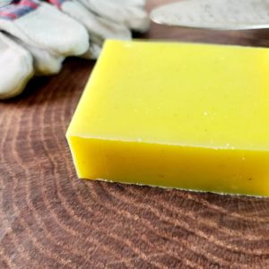 A picture of yellow soap next to gardening tools.