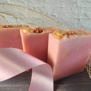 A picture of three pink soap bars with gold swirls and gold rose embeds on the top.