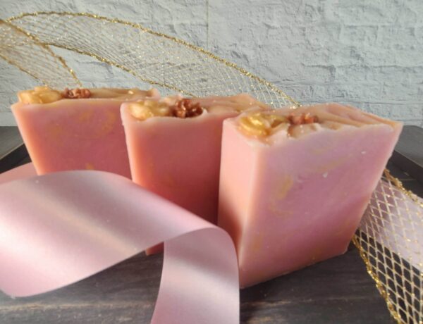 A picture of three pink soap bars with gold swirls and gold rose embeds on the top.