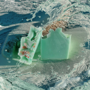 Sea green soap on a beach with a wave of water coming over it.