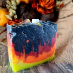 A Black, orange, and red swirled soap designed to resemble the flame of a bonfire. Complete with a marshmallow soap imbed on top.