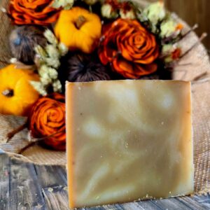 A white and brown swirled soap in front of Fall flower bouquet.