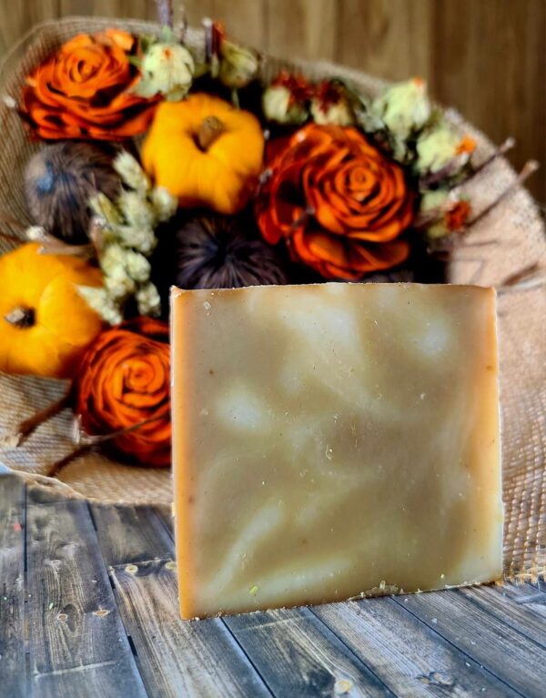 A white and brown swirled soap in front of Fall flower bouquet.