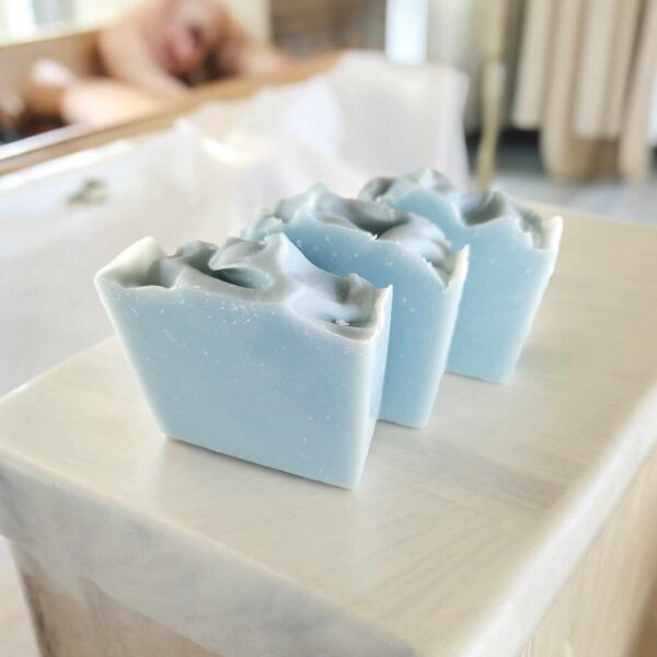 Three light blue soaps on a white kitchen countertop.