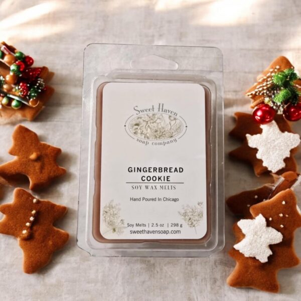 A package of six brown colored wax melts sitting on a flour covered table surrounded by gingerbread cookies.